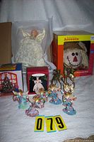 Group shot of all items in lot including scarecrow box, angel ornaments, candle holders, candlelight box and angel topper