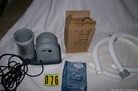 Complete lot laid out: pump, hoses, fittings in box, manual
