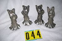 All four pewter angel candle holders standing side by side