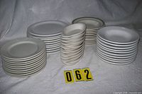 Stacks of five types of white dinnerware showing overall quantity