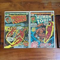 Front covers of both "The Human Torch" comic books showing issue numbers and 25¢ price
