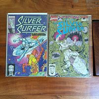 Both Silver Surfer comics side by side in bags