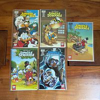 All five Uncle Scrooge comic books bagged on tabletop