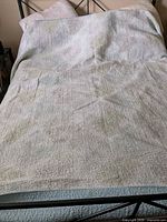 Quilt spread on bed showing mottled white side