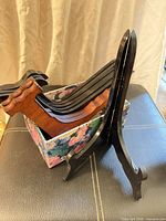 Group of plate holders inside floral box with one black stand open
