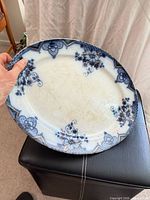 Front view of blue and white floral oval platter showing gold trim and surface staining