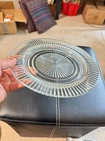 Front view of clear glass dessert plate showing starburst center and ribbed edge