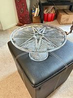 Top view of clear pressed glass cake stand showing starburst pattern