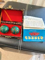 Baoding balls in open box beside instruction leaflet
