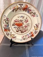 Full view of floral transferware dinner plate on stand