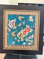 Frontal view of framed silk embroidery showing overall artwork and frame