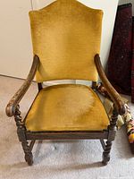 Front view of gold velvet wooden armchair