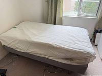Twin mattress on light gray IKEA Sultan base in room setting