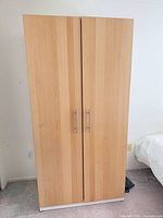 Front view of closed two-door beech wardrobe
