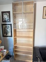 Full view of tall display cabinet showing glass doors and shelves