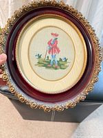 Front view showing needlepoint image and ornate frame