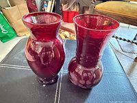 Front view of both ruby glass vases standing side by side