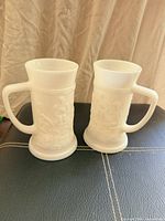 Front view of the two white milk glass handled drinking glasses