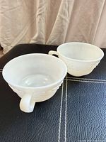 Both milk glass teacups side by side on surface