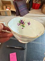 Side view of Paragon creamer showing handle, violet pattern, gilt rim and foot