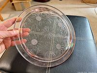 Front view of pink pressed glass plate showing floral pattern
