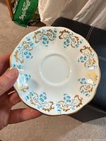 Front view of Royal Albert Rocaille saucer showing full pattern and gilt rim