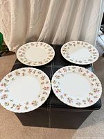 Four matching Royal Albert Winsome plates on ottoman