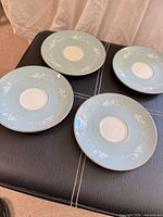 Top view of four Royal Doulton Reflection saucers showing color, pattern and gold trim