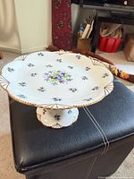 Full view of Royal Stafford pedestal cake stand on ottoman