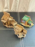 All three ceramic hut figurines grouped together