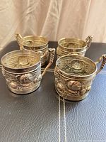 set of four silver-plated holders on surface