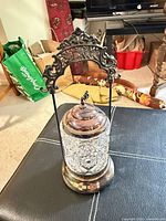 Full view of biscuit barrel on stand displaying handle, lid, glass insert and foot