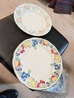 Two plates showing distinct fruit and floral patterns