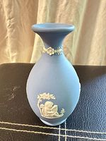 Front view of blue Jasperware vase showing cherub relief