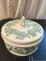 Top view of Wedgwood cream box with pale green grapevine relief and finial lid