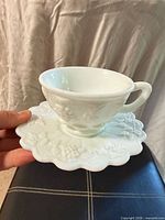 Teacup on saucer showing grape relief pattern