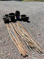 Group of bamboo stakes, plastic pots and chain hangers on ground
