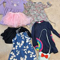 Overview of all garments and purse laid out on surface