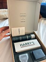 Open Harry’s kit showing handle, blades, shave gel, cover, booklet inside box