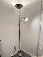 Full view of brushed nickel torchiere floor lamp in corner