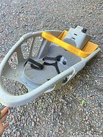 Front/side view of gray and yellow child bike seat showing harness and padding
