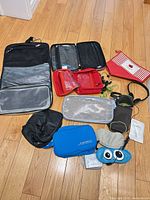Group view of all toiletry bags, pouches, earbuds, headphones and masks