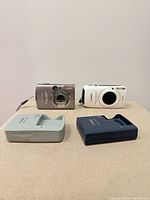 Front view of both Canon PowerShot cameras and chargers