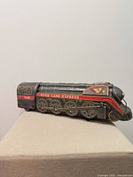 Side view of tin locomotive showing Over Land Express graphics and wheels
