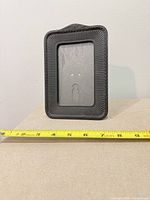 Back view showing keyhole slot, hanger holes, and size tape for scale