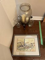 group shot of framed print, hurricane vase on stand, two small vases