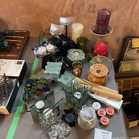 Overall view of assorted candle holders, candles, glass and wood décor on table