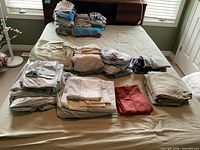 Stacked sheets and pillowcases on bed in assorted colours