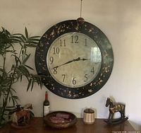 Front view of large black-framed clock on wall