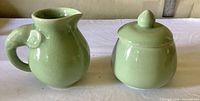Cream pitcher and lidded sugar bowl front view showing glaze and form